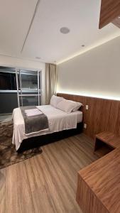 a bedroom with a bed and a large window at Moov 2415 Studio Mooca in Sao Paulo