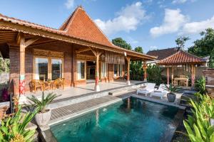 a house with a swimming pool in front of it at Atta Villa in Karangasem