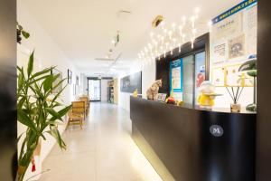 a lobby of a hospital with a reception counter at Meriden M Hotel Beijing - Sanlitun Tuanjiehu Subway Station in Beijing