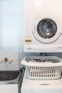 a washing machine on a shelf next to a sink at Beachfront Terraces with Onsite Reception & Check In in Port Douglas