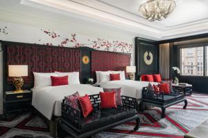 a hotel room with two beds and red pillows at THE KARL LAGERFELD in Macau