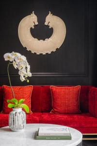 un sofá rojo con un jarrón de flores sobre una mesa en THE KARL LAGERFELD, en Macau