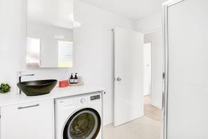 a white laundry room with a washer and dryer at Tropical Terraces in Cairns