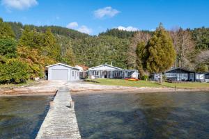 a house on the shore of a body of water at The Middle in Rotoiti