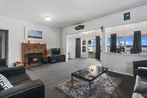 a living room with a couch and a fireplace at The Middle in Rotoiti