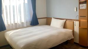 函館市にある東横INN函館駅前大門の窓のある部屋にある小さなベッド +28枚の写真