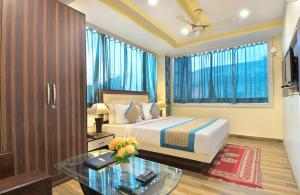 a bedroom with a bed and a glass table at Hotel Castle Blue in New Delhi