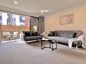 a living room with a couch and two chairs at Modern & Central City in Hamilton