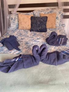 een bed met paarse handdoeken en kussens erop bij Hospedagem Recanto das Orquideas in Quatis