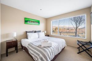 a bedroom with a large bed and a window at Criffel Garden Apartment in Wanaka