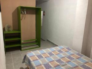 1 dormitorio con 1 cama y armario verde en La Fortaleza, en Tonatico