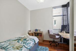 een slaapkamer met een bed, een bureau en een stoel bij Sunny Bondi Retreat: Beach & Culture Unite! in Sydney