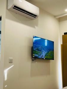 un téléviseur à écran plat accroché au mur dans l'établissement Studio Luxury Sakura - Vinhome Smart city Mỹ Đình, à Hanoï