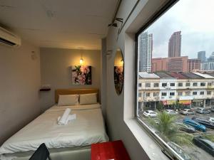 um pequeno quarto com uma cama e uma janela em DingDong Bukit Bintang Luxury Suites,3mi to PaVlion mall em Kuala Lumpur