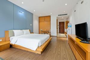 a bedroom with a large bed and a flat screen tv at 22HOUSING 48 Phan Kế Bính in Hanoi