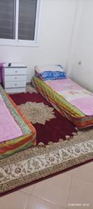 3 camas sentadas en el suelo en una habitación en Jolie Maison pas chère en Oujda