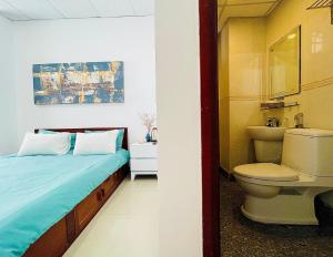 een badkamer met een bed, een wastafel en een toilet bij Onestar Danang Riverside in Da Nang
