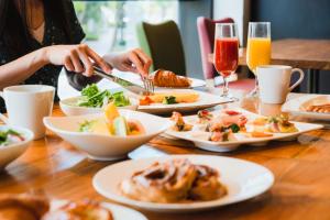 a table with plates of food and glasses of orange juice at Hotel Nikko Kanazawa in Kanazawa