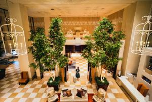 a woman walks through the lobby of a building with trees at Hotel Nikko Kanazawa in Kanazawa
