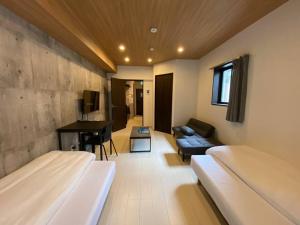 um quarto com 2 camas, um sofá e uma secretária em リブレ in Kumamoto 302 em Kumamoto