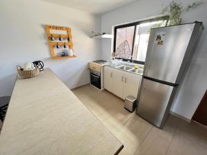 a kitchen with a stainless steel refrigerator and a sink at Casa con vista al mar! in Tomé