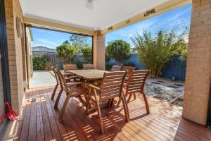 una mesa de madera y sillas en una terraza de madera en Shiloh House, en Paynesville