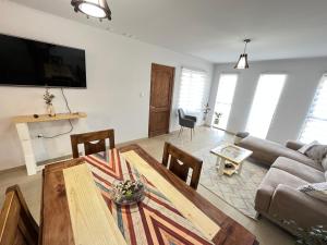 a living room with a table and a couch at Casa con vista al mar! in Tomé