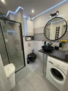 y baño con lavadora y espejo. en Apartament 20 en Radków