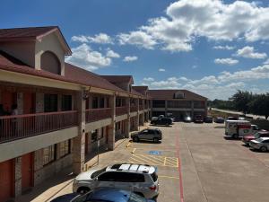 a parking lot with cars parked in front of a building at Super 8 by Wyndham Stafford Sugarland Area in Stafford