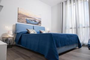 馬卡里的住宿－Casa Bambù con piscina a Macari，一间卧室配有蓝色的床和蓝色的毯子