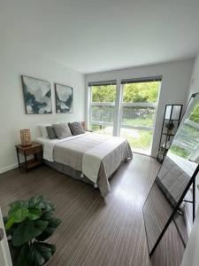 a bedroom with a bed in a room with windows at One bedroom luxury apartment (Gym, Wifi, Parking, Rooftop Deck) in Seattle