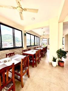 a dining room with tables and chairs and windows at Hotel Adam in Pokhara