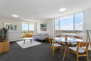 uma sala de estar com uma mesa e cadeiras e um sofá em CRE31 - renovated 1 bedroom unit - Cremorne em Sidney