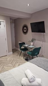 Schlafzimmer mit einem Bett und einem Tisch mit Stühlen in der Unterkunft Cambridge Suites in Harmondsworth