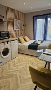 a bedroom with a bed and a washing machine at Cambridge Suites in Harmondsworth