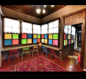 a room with colorful stained glass windows and a table and chairs at LORDS HOSTEL & PUB in Antalya