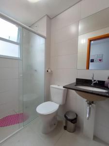 um banheiro com vaso sanitário, chuveiro e pia em Apartamento Jardim das Palmeiras II - Ubatuba em Ubatuba