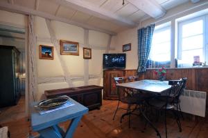 a living room with a table and a television at Gite Chez Marianne in Riquewihr
