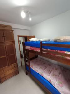 um quarto com dois beliches e uma cômoda em Apartamento Jardim das Palmeiras II - Ubatuba em Ubatuba mais 7 fotografias