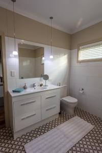 a bathroom with a sink and a toilet and a mirror at Meander Retreat - The Green Room in Springton
