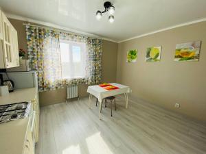 una pequeña cocina con mesa y ventana en 2.х полноценная . ЖК комфорт., en Kokshetau