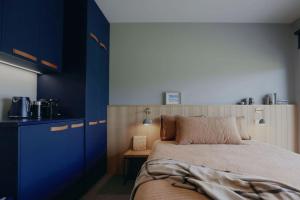 a bedroom with a bed and a blue cabinet at Stony Rise Lodge in Robe