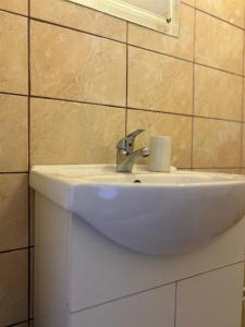 lavabo blanco en el baño con espejo en Căsuța Dede en Buzau