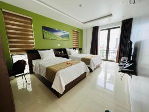 Habitación de hotel con 2 camas y TV de pantalla plana. en Phúc Lâm Hotel en Ha Giang