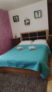 um quarto com uma cama grande e um cobertor azul em Casa Mamei em Suceava
