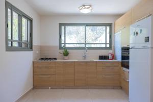 a kitchen with wooden cabinets and a white refrigerator at Desert Pearl in Beer Sheva