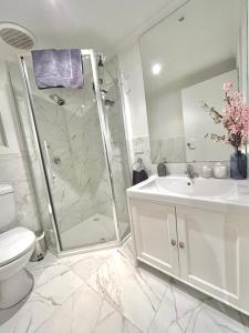 a bathroom with a shower and a sink and a toilet at Villa Panorama in Kalorama