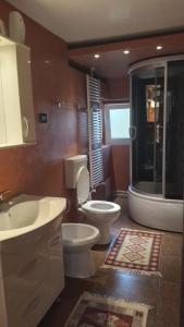 La salle de bains est pourvue de toilettes et d'un lavabo. dans l'établissement Casa Mamei, à Suceava