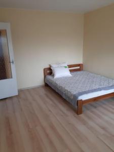 a bedroom with a bed and a wooden floor at Independent apartment in varena in Varėna