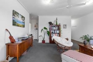 a living room with a couch and a guitar in it at Simply Kensington by Ready Set Stay in Melbourne